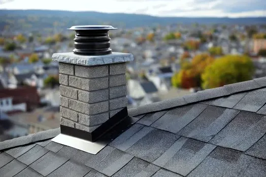 Stone chimney with cap and flashing in Sherrills Ford